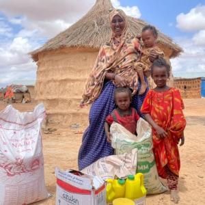 Abshiro and children with food purchased with cash assistance. 