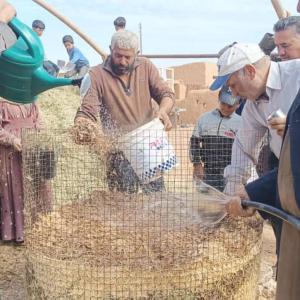 Ibrahim (center) and other farmers learn to make compost.