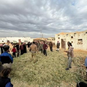 Farmers gather outside of Ibrahim’s home for Farm Field School.