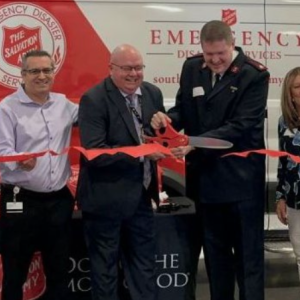FedEx volunteer assists with ribbon cutting event marking the donation of a mobile canteen by FedEx