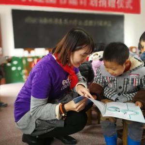 teacher looking at a book with child