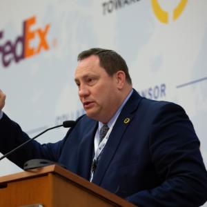A man in a suit talking at a podium