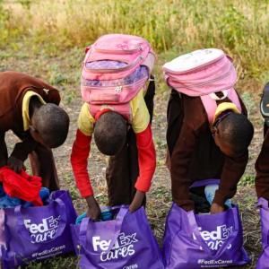 Children looking through purple fedex cares bags