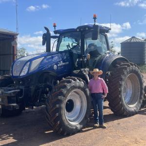 A person standing by a large tractor outside.