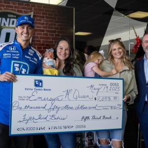 Family poses with large check