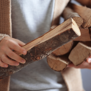 A person holding chopped wood
