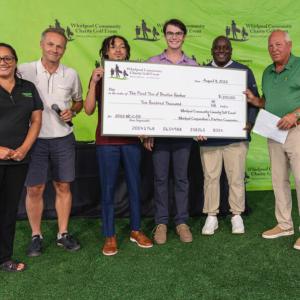 Representatives from First Tee of Benton Harbor pose with a large check