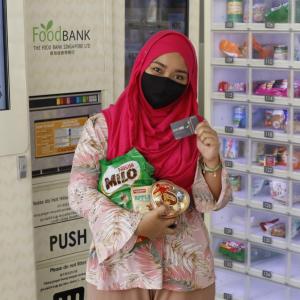 Woman holding up her food bank card
