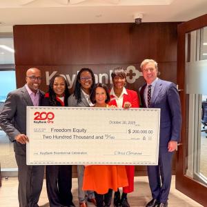 Freedom Equity and KeyBank representatives shown with a $200,000 grant check.
