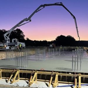 Framing around wet concrete and trucks in the distance.