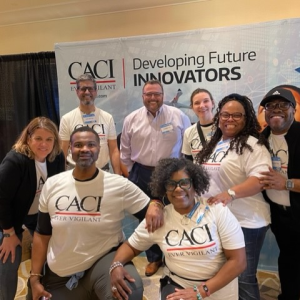 A group posed for the camera wearing matching CACI t-shirts.