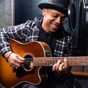 Kameron Corvet; playing a guitar