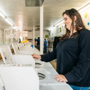 Christy Moore, Social Spin Laundromat AEO in Partnership; standing in a laundromat.