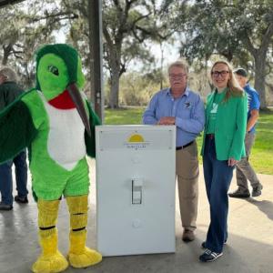 Gulf Coast Bird Observatory Executive Director, Martin Hagne, with mascot and Rebecca Emrick from Green Mountain Energy Sun Club at the "Flip the Switch" event on January 8.