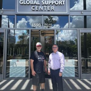 2 people stand together outside the Sysco Global support Center