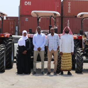 Gaalooge team members standing in front of several tractors