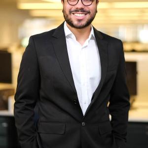 Gabriel Cunha smiling with their hands in their trouser pockets