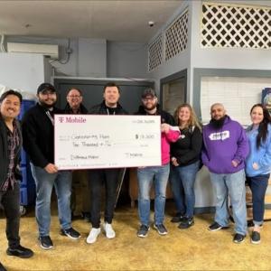 A group of people holding a donation cheque for the shelter Generating Hope