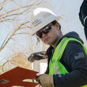 Georgia Hummel in safety wear, looking at a panel outside.