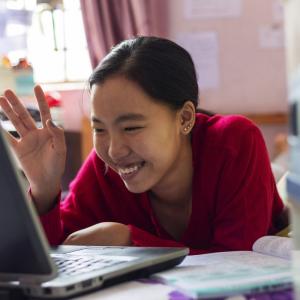 Person smiling while using a laptop