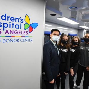 Group standing near sign reading, "Children's Hospital Los Angeles Blood Donation Center"