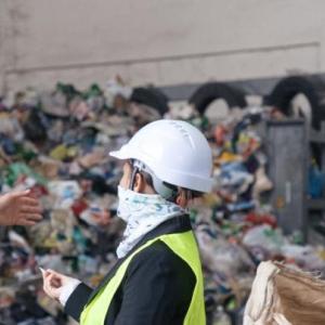 Two workers speaking in front of a landfill