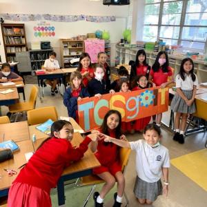 A group of school kids holding TCS goIT sign