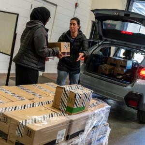 People loading boxes into a vehicle