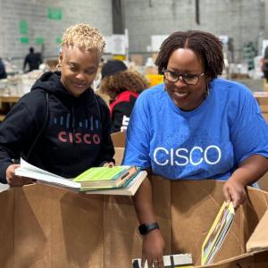 Two people filling  boxes with books