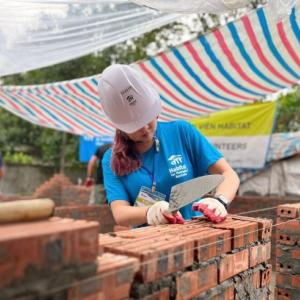 person wearing a hard hat building a structure