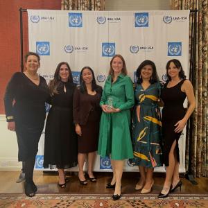 A group of people stood together in front of a UNA.USA back drop 