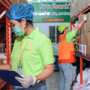 two workers in ppe collecting food items from a warehouse