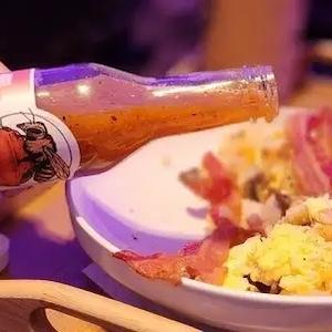 Salce being added to eggs and bacon.