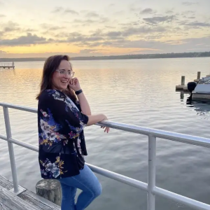 Jenny Oliveira on the edge of a dock looking over the water.