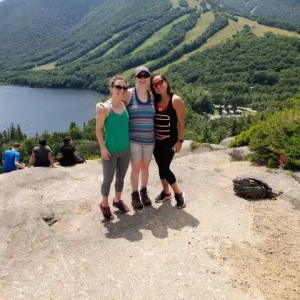 Jenny Oliveira on a hilltop with two other people.