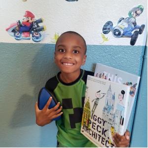 Photo of a young child holding a book.