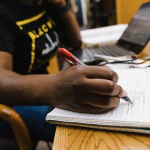 Student taking notes in a class.