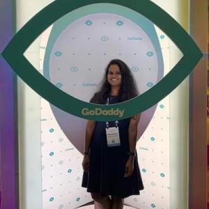 Prashanthi in front of a Hello, Visionary sign.