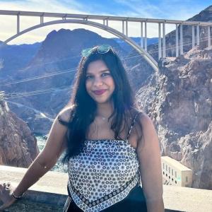 Sathvika in front of a gorge with a bridge in the background.