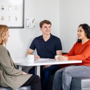 Three people seated at a table.