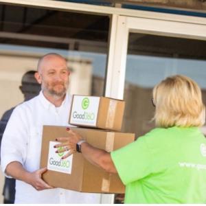 Person handing another person two boxes