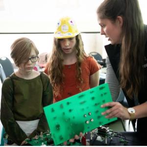 Grace Doepker showing a young children some equipment