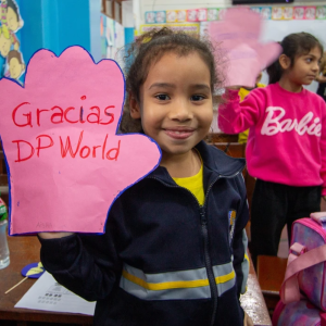 Child with artwork that says " Gracias DP World"