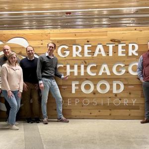 A group posed by a large sign "Greater Chicago Food Depository"