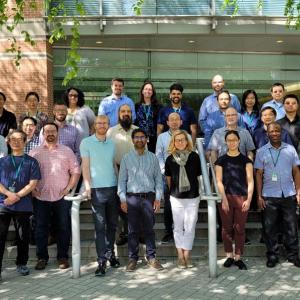 Team of people posed outside a building.