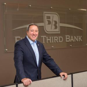 Photo of Greg Carmichael in front of Fifth Third Bank sign