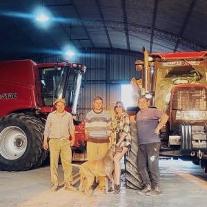 Group photo with dog in front of tractors