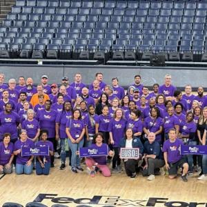 Large group photo of people wearing purple Fedex cares tshirts