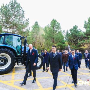 People walking past a CNH tractor into the event