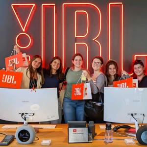 HARMAN interns posing in front of a JBL sign.